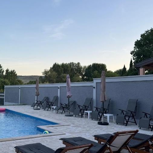 Sun loungers and parasols beside the private pool at Villa Verona at sunset
