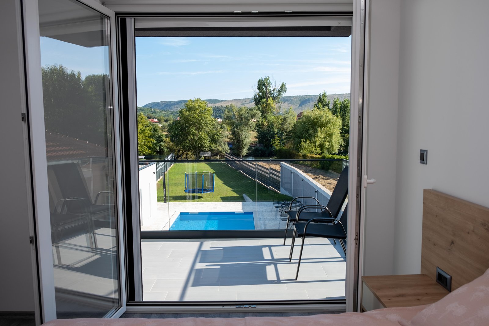 Bedroom window view over the private pool and garden at Villa Verona in Blagaj
